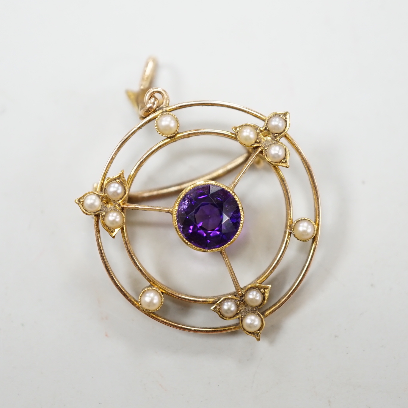 An Edwardian 15ct, amethyst and seed pearl set pendant brooch, overall 36mm, gross weight 4.1 grams, in fitted leather box.